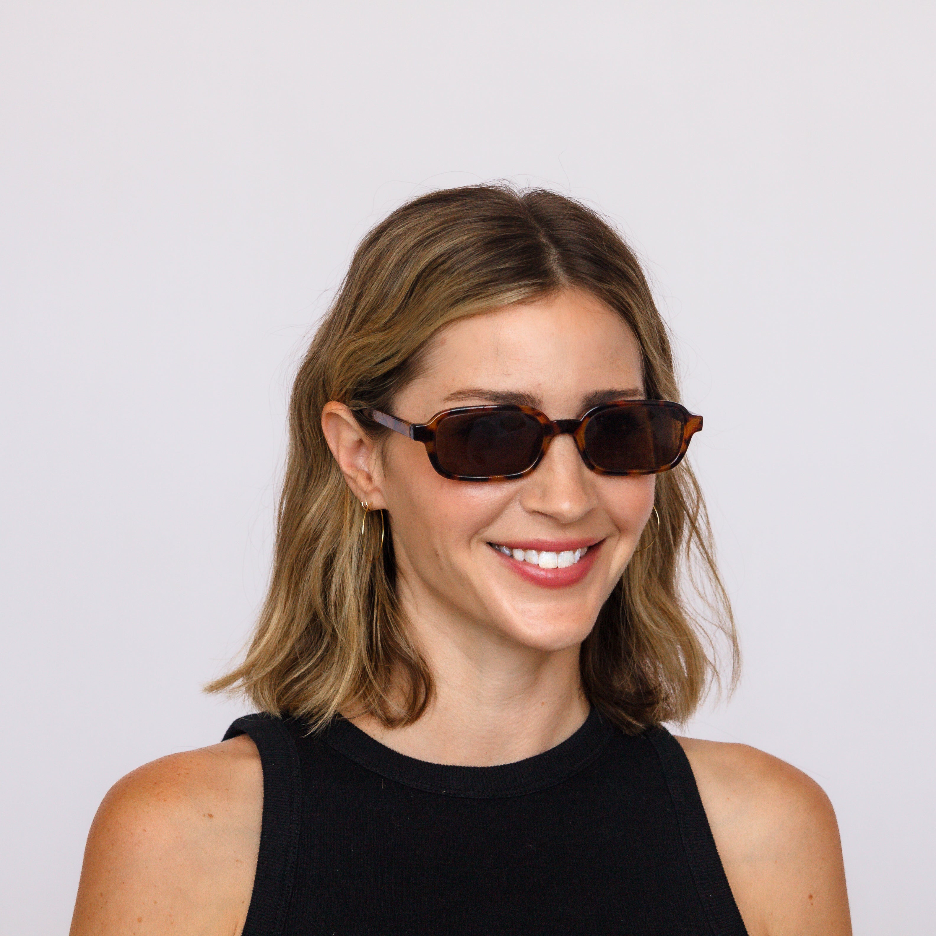 A model in Jaxy Velvet Hour rectangle sunglasses, lifestyle shot